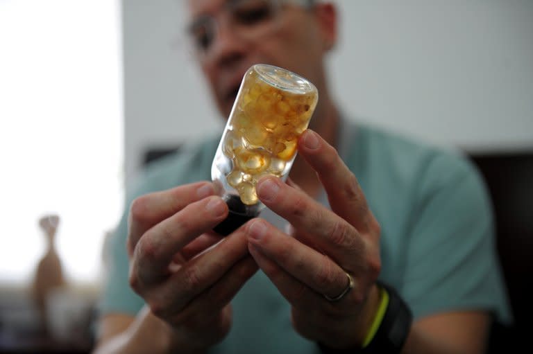 In an interview with AFP in Caracas on August 8, Daniel Slobodianik holds a jar of biopolymer taken from a patient. The "No to Biopolymers Foundation" has knowledge of 40,000 people who opted for the procedure, and the number is growing