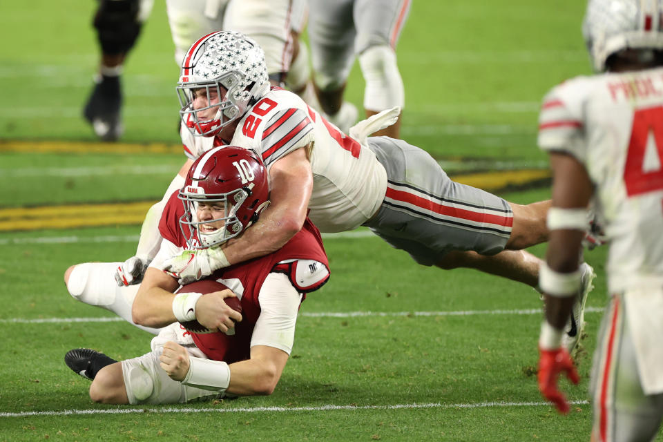 MIAMI GARDENS, FLORIDA - JANUARY 11: Pete Werner #20 of the Ohio State Buckeyes tackles Mac Jones #10 of the Alabama Crimson Tide during the College Football Playoff National Championship at Hard Rock Stadium on January 11, 2021 in Miami Gardens, Florida. (Photo by Jamie Schwaberow/Getty Images)