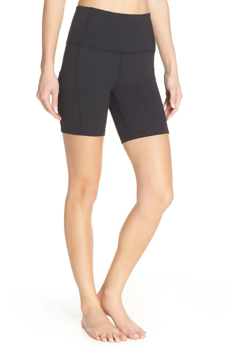 model wears black Zella Live In High Waist Pocket Bike Shorts. Image via Nordstrom.