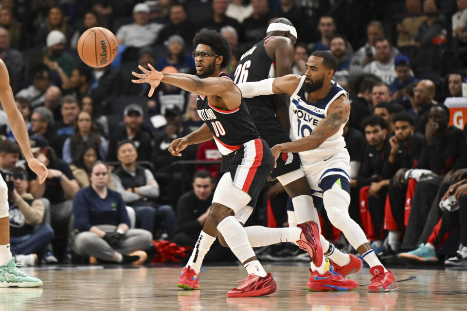 Portland Trail Blazers guard Scoot Henderson (00) passes the ball as center Duop Reath, center, sets a screen against Minnesota Timberwolves guard Mike Conley during the first half of an NBA basketball game Friday, Jan. 12, 2024, in Minneapolis. (AP Photo/Craig Lassig)
