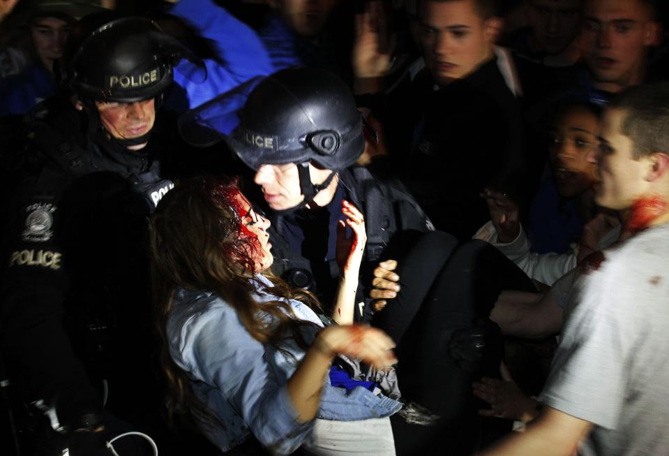 ATTENTION EDITORS - VISUAL COVERAGE OF SCENES OF INJURY OR DEATH A Lexington police officer carries an injured University of Kentucky student after she was hit on the head with a bottle on the streets, after the University of Connecticut defeated Kentucky in the NCAA men's National Basketball Championship, near the university campus in Lexington, Kentucky, April 7, 2014. Connecticut's experience trumped Kentucky's youth as the Huskies prevailed with a 60-54 NCAA national championship victory on Monday that completed a turnaround for the recently penalized program. REUTERS/ John Sommers II (UNITED STATES - Tags: SPORT BASKETBALL TPX IMAGES OF THE DAY) TEMPLATE OUT