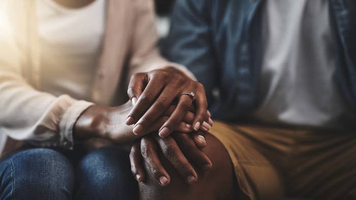 Close-up of a seated couple clasping hands