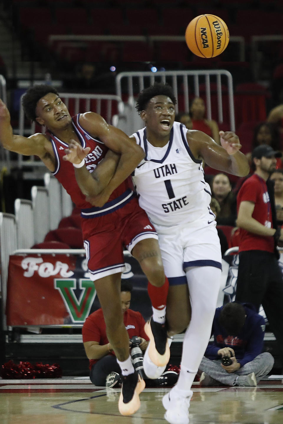 Utah State's Great Osobor battles Fresno State's Leo Colimerio during the first half of an NCAA college basketball game in Fresno, Calif., Tuesday, Feb. 27, 2024. (AP Photo/Gary Kazanjian)