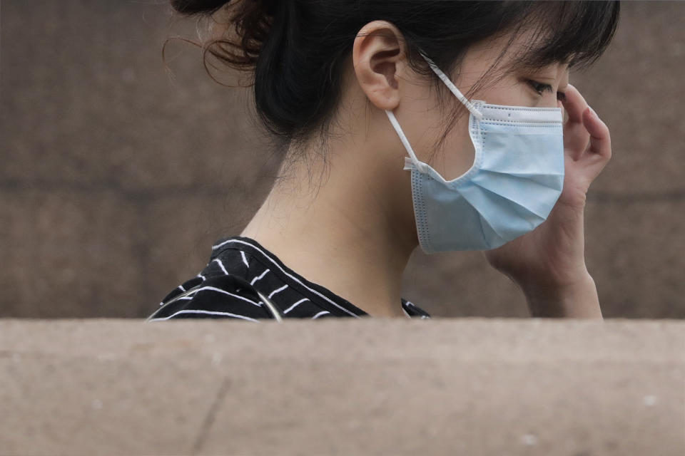 A woman wearing a face mask walks down to an underground tunnel in Beijing, Tuesday, July 28, 2020. New coronavirus cases continue to rise in China's northwestern region of Xinjiang, with dozens of cases reported on Tuesday. The capital Beijing also reported its first case of domestic transmission in more than two weeks, while the northeastern province of Liaoning added another several cases in its local outbreak. (AP Photo/Andy Wong)