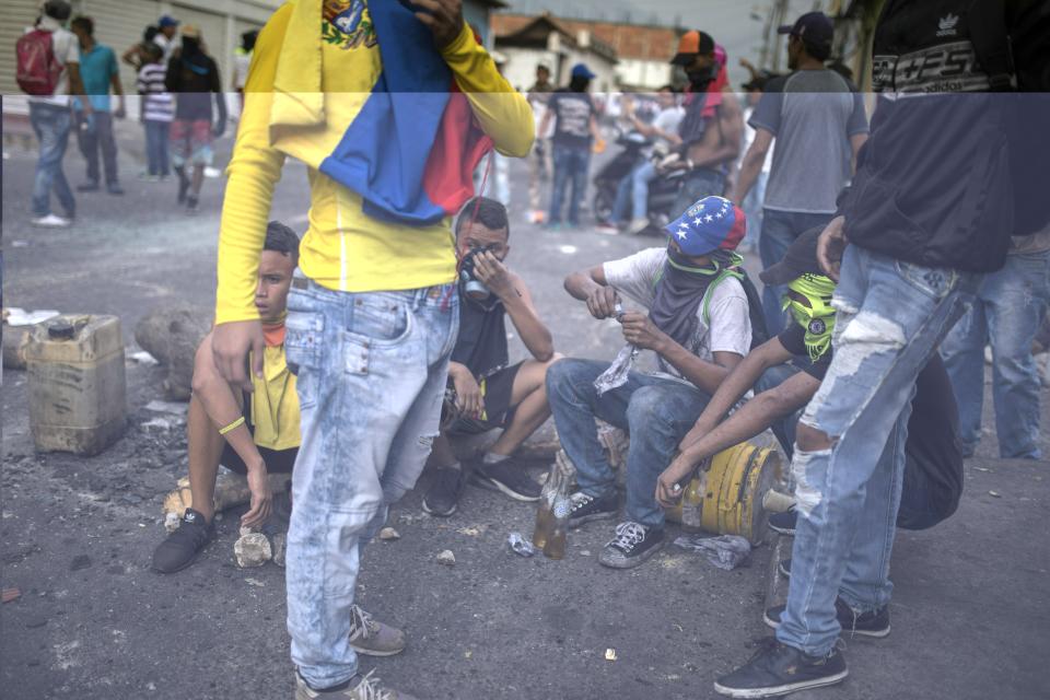 Demonstrators gather after clashing with the Bolivarian National Guard in Urena, Venezuela, near the border with Colombia, Saturday, Feb. 23, 2019. Venezuela's National Guard fired tear gas on residents clearing a barricaded border bridge between Venezuela and Colombia on Saturday, heightening tensions over blocked humanitarian aid that opposition leader Juan Guaido has vowed to bring into the country over objections from President Nicolas Maduro. (AP Photo/Rodrigo Abd)