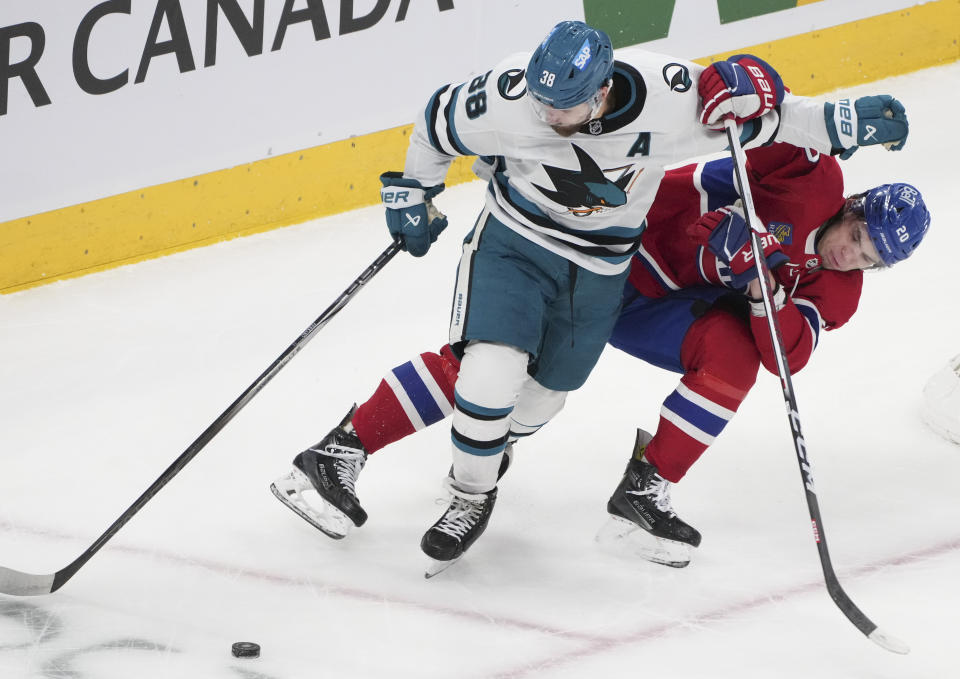 San Jose Sharks' Mario Ferraro (38) and Montreal Canadiens' Juraj Slafkovsky (20) battle for the puck during first-period NHL hockey game action in Montreal, Thursday, Jan. 11, 2024. (Christinne Muschi/The Canadian Press via AP)