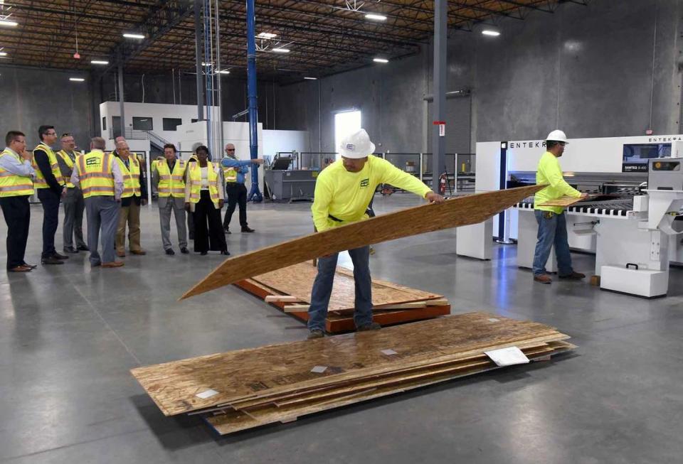 In this November 2019 file photo, employee Gilberto Naranjo places precut sheeting on a pile after using an optimizer to cut them at Entekra in Modesto, Calif.