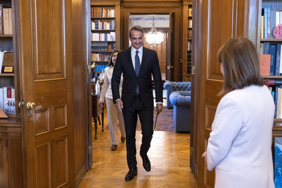 Greece's Prime Minister Kyriakos Mitsotakis, center, arrives for a meeting with Greek President Katerina Sakellaropoulou at the Presidential palace, in Athens, Saturday, April 22, 2023. Mitsotakis visited the Greek President to officially announce a general election on May 21. (AP Photo/Yorgos Karahalis)