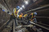 This June 15, 2019 photo provided by the Metropolitan Transportation Authority shows workers during the L Project subway tunnel rehabilitation, in New York. Eight years ago Thursday, Oct. 29, 2020, Superstorm Sandy pushed the Hudson River over its banks, sending 8 feet of water onto underground tracks and leaving the main waiting room unusable for months. New York's Metropolitan Transportation Authority, which serves several million riders daily on subways, trains and buses, had to repair damage to more than a dozen bridges and tunnels, many pre-dating World War II, caused by tens of millions of gallons of saltwater. (Trent Reeves/Metropolitan Transportation Authority via AP)