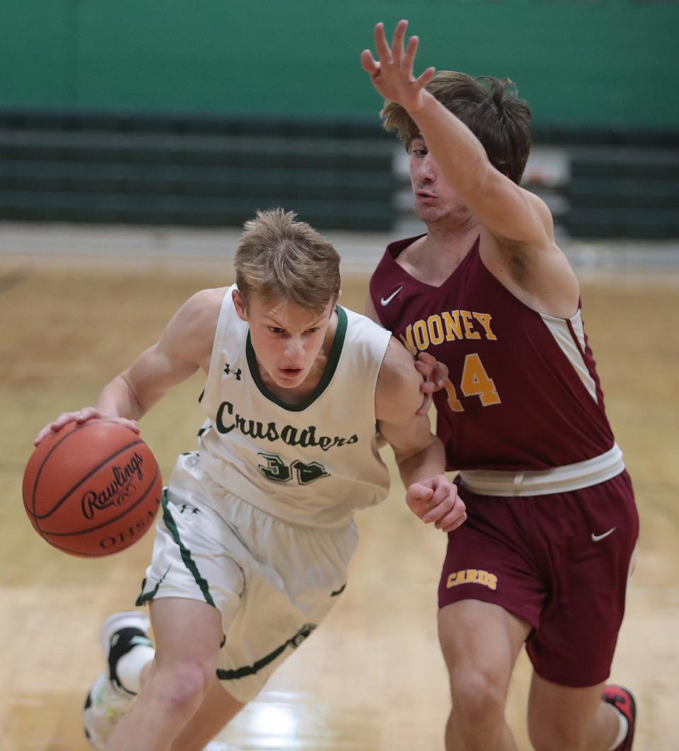 Central Catholic's Luke Vlacovsky drives to the hoop with pressure from Cardinal Moody's Nick Pregibon in the first half at Central's home game with Cardinal Mooney Tuesday, December , 27.