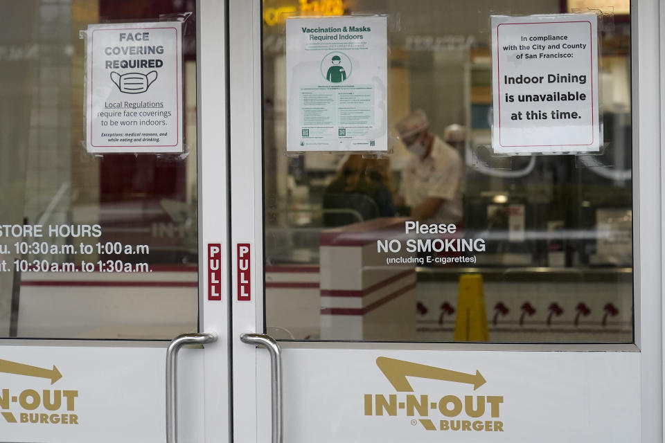 FILE - In this Oct. 20, 2021, file photo, signs advising vaccination and face mask requirements and no indoor dining are displayed on the door of an In-N-Out restaurant in San Francisco's Fisherman's Wharf. The restaurant's indoor dining was shut down this month by health authorities for not demanding proof of vaccination. (AP Photo/Jeff Chiu, File)