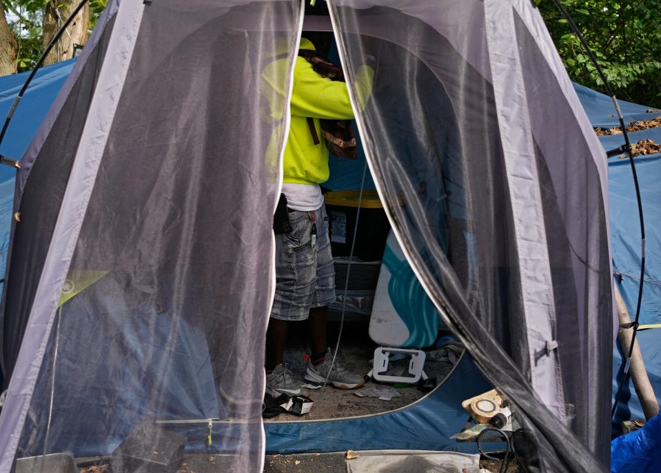 Tim Marshall removes lights hanging inside his tent Monday at Camp Shameless as he and many remaining residents prepared to move into temporary, transitional housing as part of a pilot program by the city.