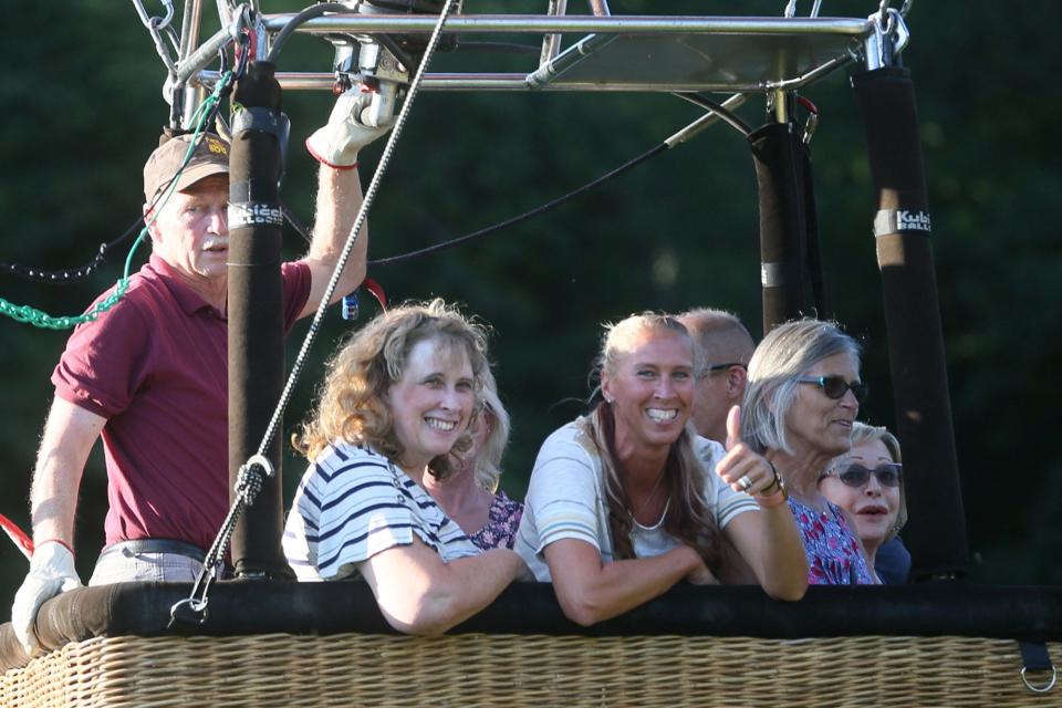 Balloon pilot Denny Wesler,. left, lifts off Friday evening with six passengers for a flight above Portage County.