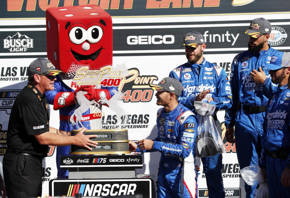 South Point Hotel Casino general manager Ryan Growney, left, presents a trophy to race winner Kyle Larson in Victory Lane after a NASCAR Cup Series auto race, Sunday, Oct. 15, 2023, in Las Vegas. (AP Photo/Steve Marcus)