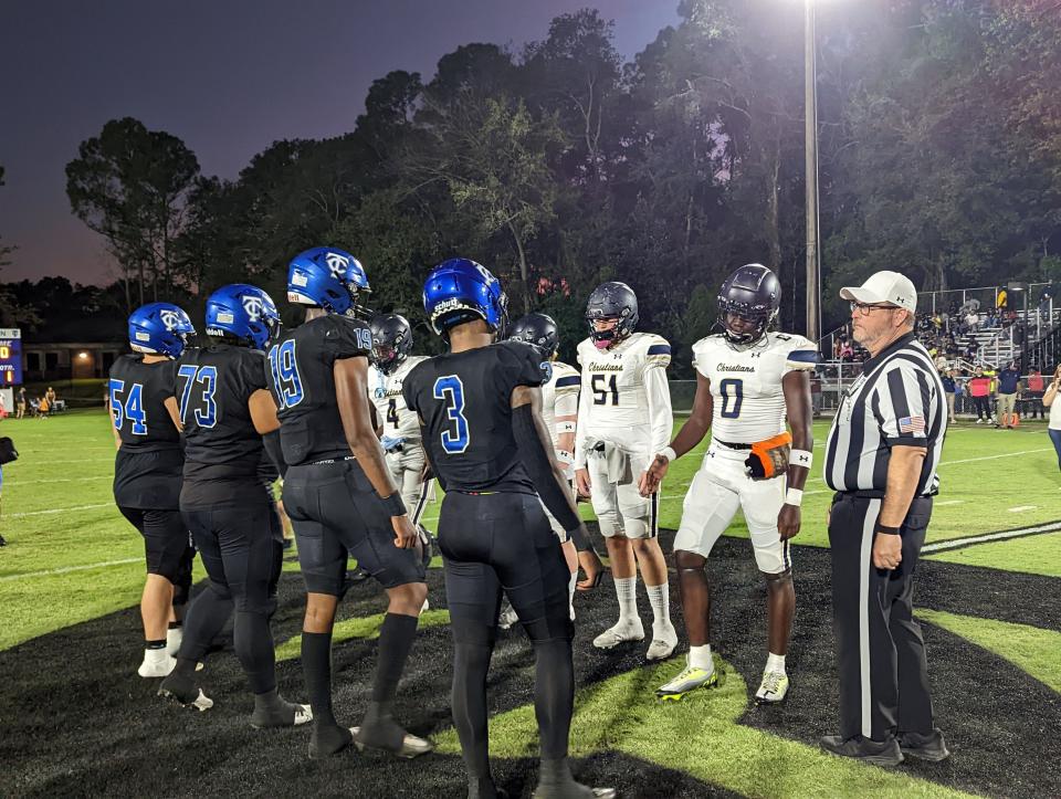 Trinity Christian and University Christian players line up for the coin toss in 2022. The district rivals face off again Friday.