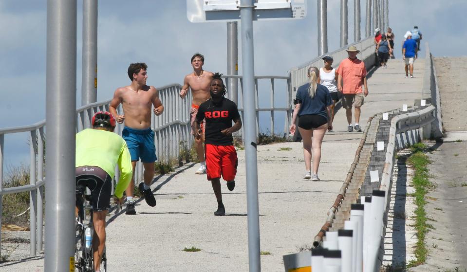 People walk, jog and bicycle over the Melbourne Causeway on a sunny Sunday afternoon. The weather system that became Tropical Storm Alex spared the Space Coast.