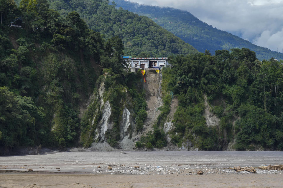 A house that was partially damaged in floods is seen by the Teesta river in Rongpo, east Sikkim, India, Sunday, Oct. 8. 2023. Rescuers continued to dig through slushy debris and ice-cold water in a hunt for survivors after a glacial lake burst through a dam in India’s Himalayan northeast, shortly after midnight Wednesday, washing away houses and bridges and forcing thousands to flee. (AP Photo/Anupam Nath)