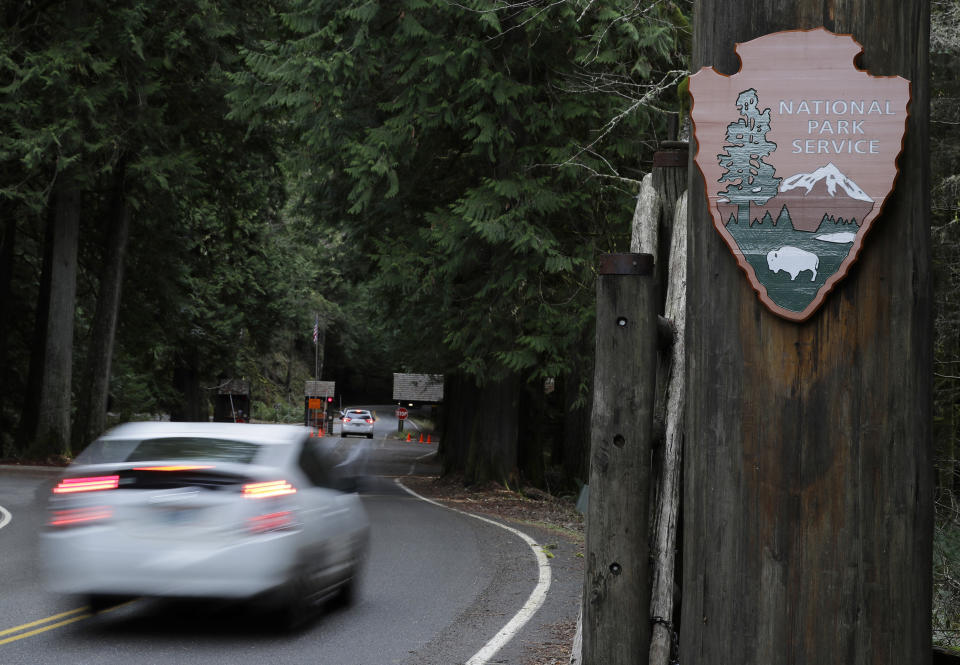 FILE - In this Jan. 28, 2019, file photo, a car drives past the Nisqually entrance to Mount Rainier National Park in Washington state. After closing amid the coronavirus pandemic, the National Park Service is testing public access at several parks across the nation, including two in Utah, with limited offerings and services. Visitor centers and campgrounds remain largely shuttered at Bryce Canyon and Capitol Reef, but visitors are welcome at some of the sites. (AP Photo/Ted S. Warren, File)