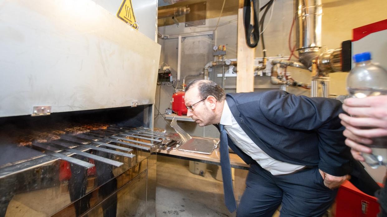 Mohammad Aleysa, Gruppenleitung Verbrennungs- und Umweltschutztechnik am Fraunhofer-Institut für Bauphysik IBP, schaut in einem Labor des IBP in einen Grill.