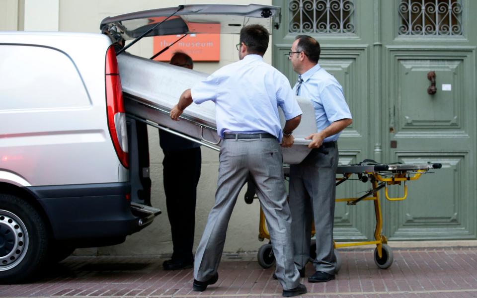 Workers bring a casket to the Dali Theater Museum  - Credit: Manu Fernandez/AP