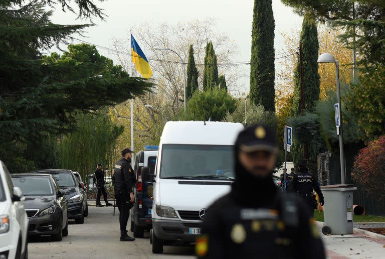 Policías españoles junto a una bandera ucraniana mientras aseguran la zona tras la explosión de una carta bomba en la embajada de Ucrania en Madrid el 30 de noviembre de 2022.