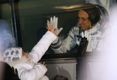 International Space Station (ISS) crew Anton Shkaplerov of Russia matches palm with his daughter Kira from a bus window before the launch of the Soyuz-FG rocket at the Baikonur cosmodrome November 23, 2014. REUTERS/Dmitry Lovetsky/Pool