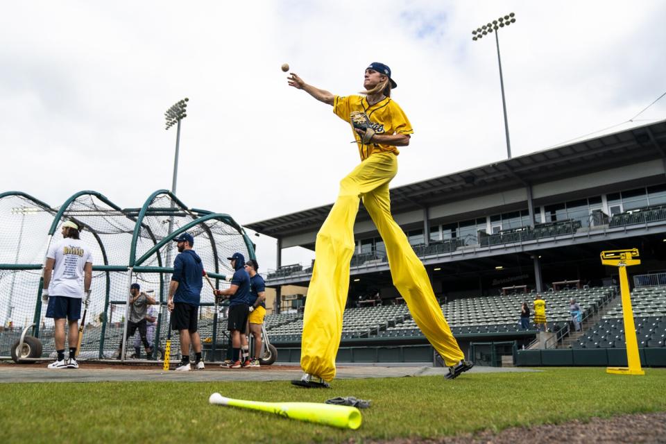 Savannah Bananas player Dakota Albritton warms up while pitching on stilts during before a game.