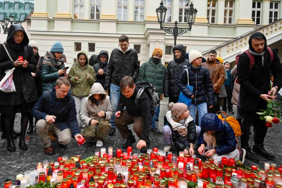 Mourners lay candles outside the Charles University building where yesterday’s attack took place (AP)