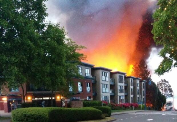 Flames seen shooting out of a four-storey building under construction in White Rock's Five Corners area on Sunday, May 15, 2016. (William Thomas Brooks - image credit)