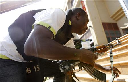 A policeman takes up position during a shootout with armed men at the Westgate shopping mall in Nairobi September 21, 2013. REUTERS/Thomas Mukoya