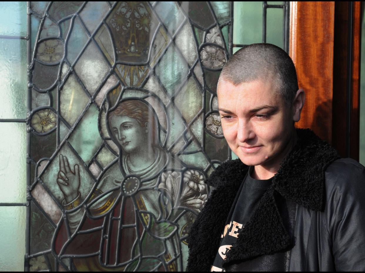 Sinead O'Connor posed at her home in front of a stained glass window.