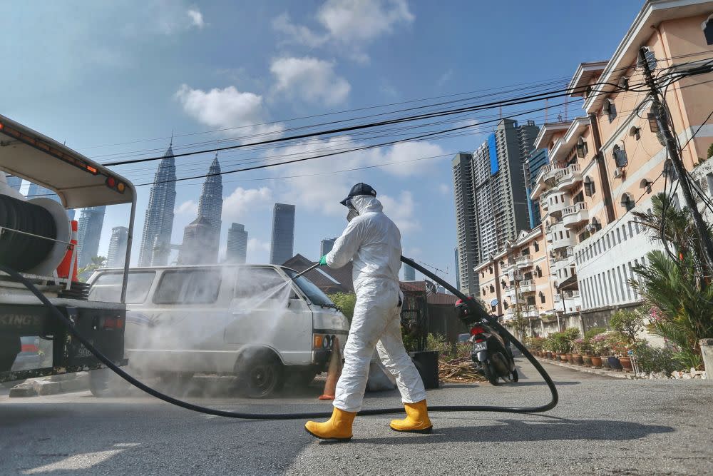 An Alam Flora personnel sprays disinfectant in Kampung Baru to curb spread of Covid-19 in Kuala Lumpur March 31, 2020. — Picture by Ahmad Zamzahuri