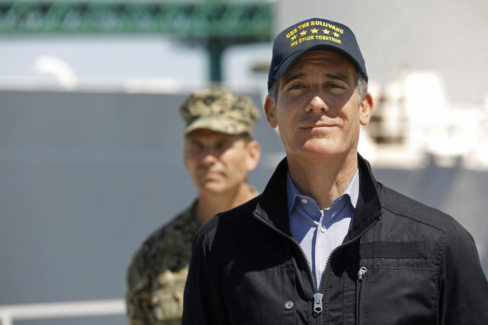 Los Angeles Mayor Eric Garcetti listens as California Governor Gavin Newsom speaks in front of the hospital ship US Naval Ship Mercy that arrived into the Port of Los Angeles on Friday, March 27, 2020, to provide relief for Southland hospitals overwhelmed by the coronavirus pandemic. Admiral John Gumbleton, U.S. Navy stands behind Mayor Garcetti. (Carolyn Cole/Los Angeles Times via AP, Pool)