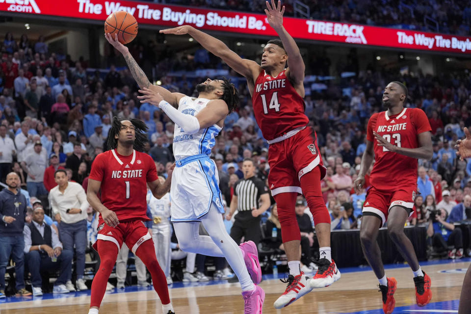 North Carolina guard RJ Davis (4) shots against North Carolina State guard Casey Morsell (14) during the second half of an NCAA college basketball game in the championship of the Atlantic Coast Conference tournament, Saturday, March 16, 2024, in Washington. (AP Photo/Alex Brandon)