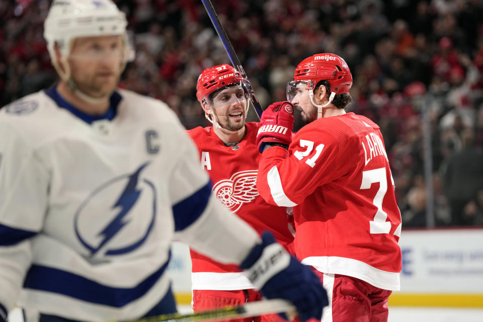 Detroit Red Wings left wing David Perron (57) and center Dylan Larkin (71) celebrate a goal by Perron during the third period of an NHL hockey game against the Tampa Bay Lightning, Wednesday, Dec. 21, 2022, in Detroit. (AP Photo/Carlos Osorio)