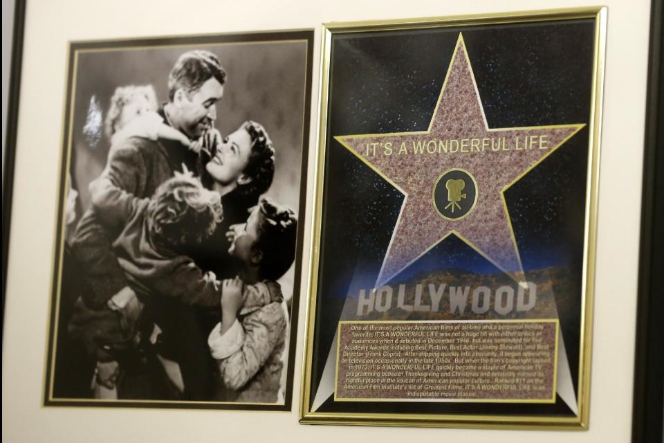 In this photo made on Friday, Dec. 20, 2013, a framed plaque with a photograph of a scene from the 1946 film "It's A Wonderful Life" starring Jimmy Stewart, left, and a Hollywood star are on display at the Jimmy Stewart Museum in Indiana, Pa. The museum dedicated to the life of the star of many films including the holiday favorite "It's A Wonderful Life" is located in the off-the-beaten track town where Stewart grew up. The museum still attracts visitors from all over the country. It’s full of displays not just about Hollywood, but about Stewart’s service as a bomber pilot in World War II, his well-to-do ancestors, and his family life. (AP Photo/Keith Srakocic)