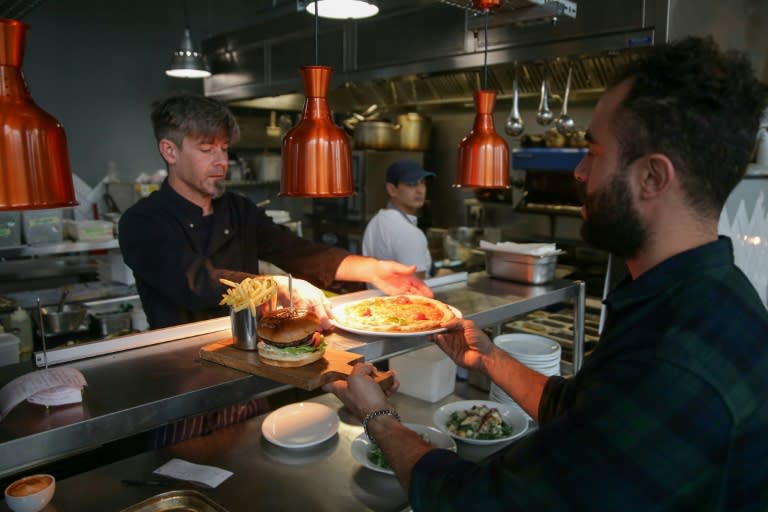 Employees working at the kitchen pick up orders in the common restaurant at the co-living building The Collective Old Oak in north-west London