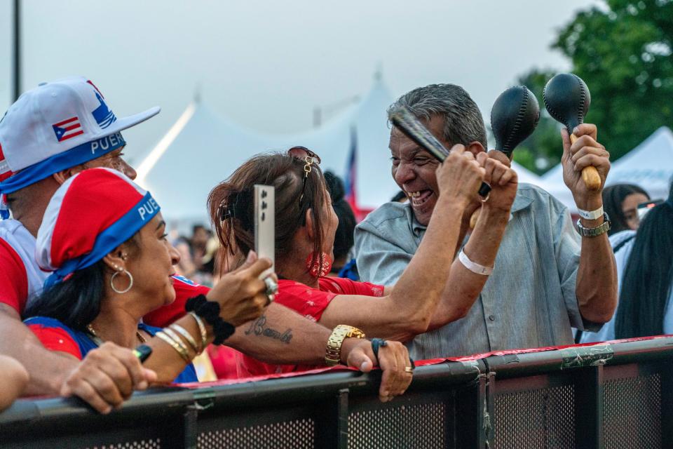 Robert Maldonado plays his maracas as he enjoys live music with other guests the Rochester Puerto Rican Festival on Thursday, August 3, 2023.