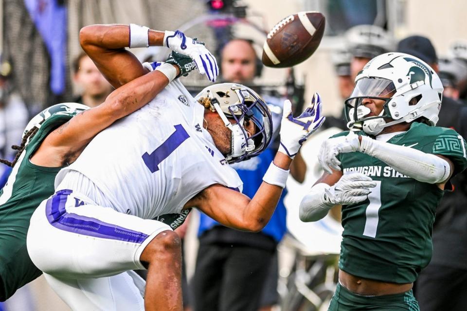 Michigan State's Marqui Lowery Jr., left, and Jaden Mangham break up a pass against Washington's Rome Odunze during the second quarter on Saturday, Sept. 16, 2023, at Spartan Stadium in East Lansing.