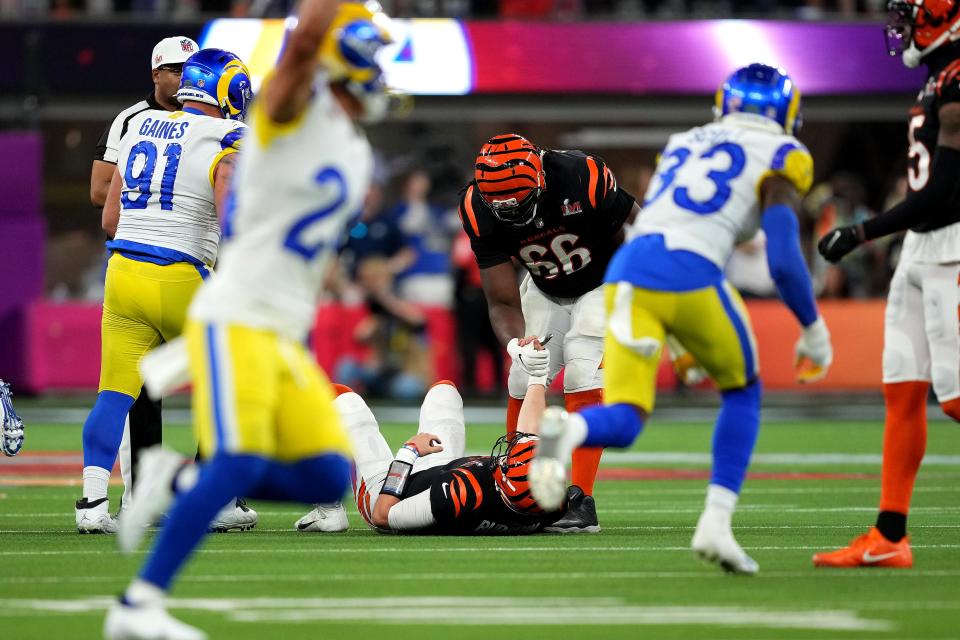 Cincinnati Bengals center Trey Hopkins (66) helps Cincinnati Bengals quarterback Joe Burrow (9) off the field after a sack by Los Angeles Rams defensive end Aaron Donald (99) (not pictured) in the fourth quarter during Super Bowl 56, Sunday, Feb. 13, 2022, at SoFi Stadium in Inglewood, Calif.