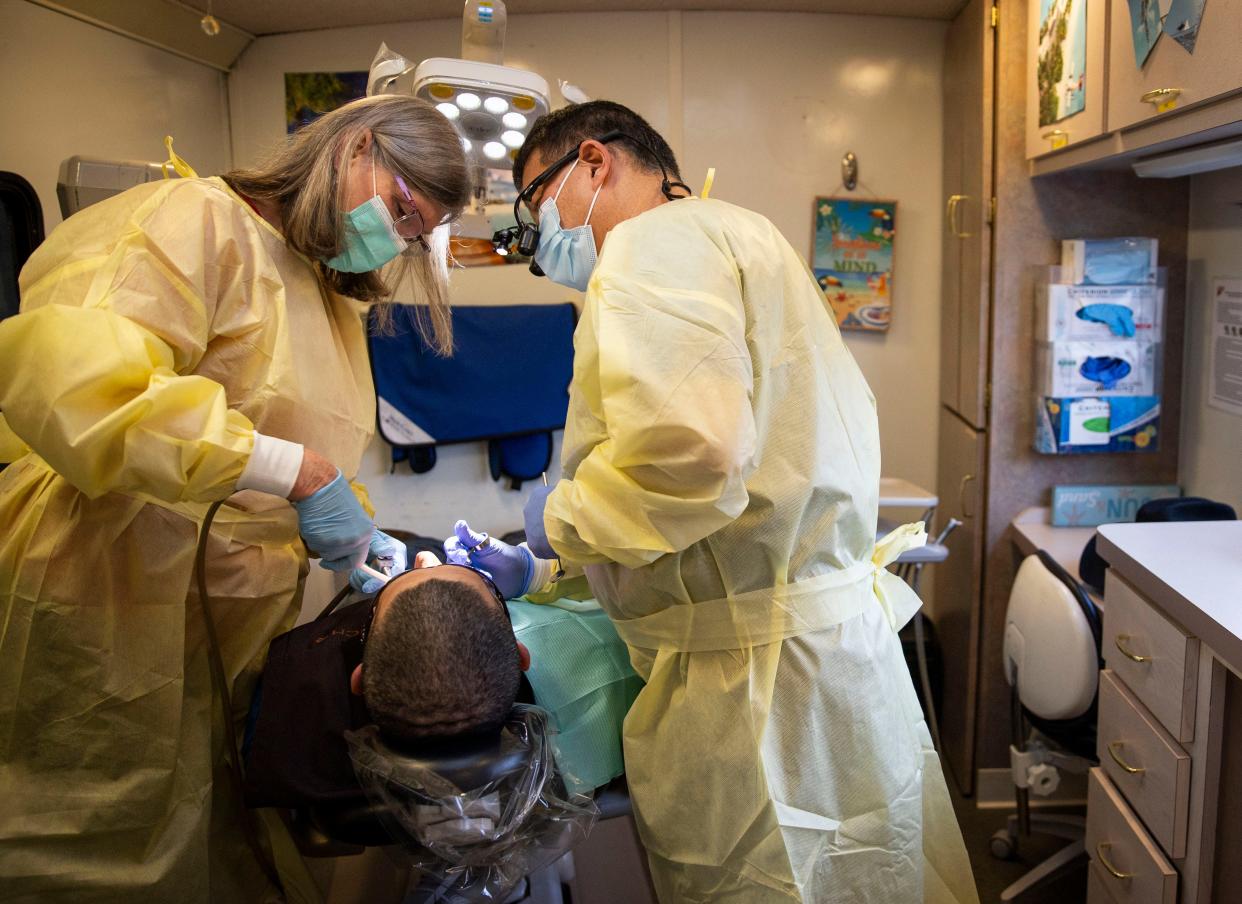 Dental assistant Kathi Karnosh and Dr. Marc Iwahiro perform an extraction Jan. 30 in the mobile dental clinic. Karnosh and Iwahiro both have volunteered with Medical Teams International for more than 20 years.