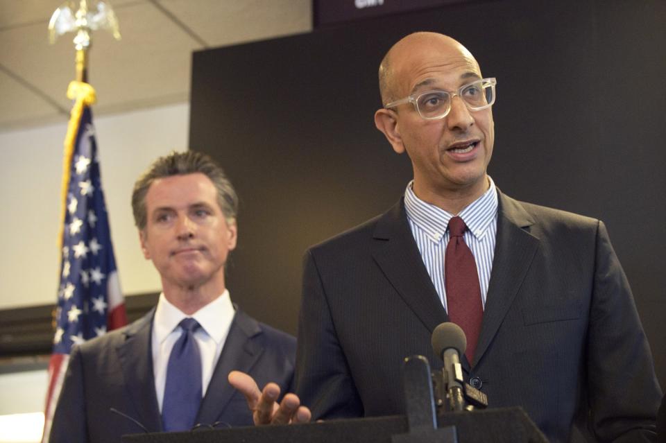 Mark Ghaly speaks at a lectern in a news conference