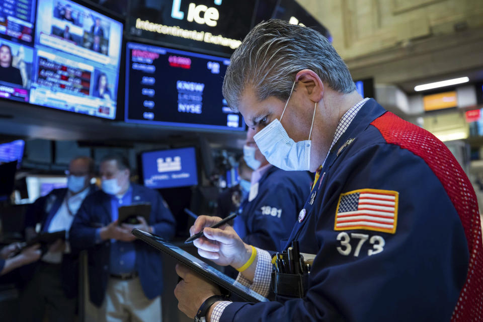 In this photo provided by the New York Stock Exchange, trader John Panin works on the floor, Friday, Jan. 21, 2022. Stocks wobbled between gains and losses on Wall Street Friday as major indexes head for another weekly loss. (Courtney Crow/New York Stock Exchange via AP)