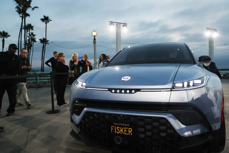 People gather and take pictures after the Fisker Ocean all-electric SUV was revealed at Manhattan Beach Pier on November 16, 2021 in Manhattan Beach, California. The event was held ahead of the Los Angeles Auto Show and AutoMobilityLA which runs November 19-28 - Photo: Mario Tama (Getty Images)