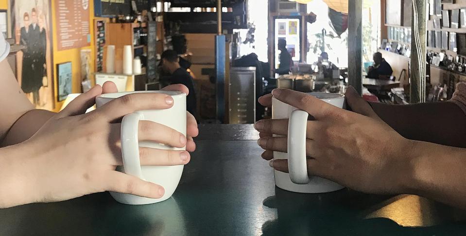 Customers at Café Domenico wrap their hands around mugs of coffee in this file photo from 2019.