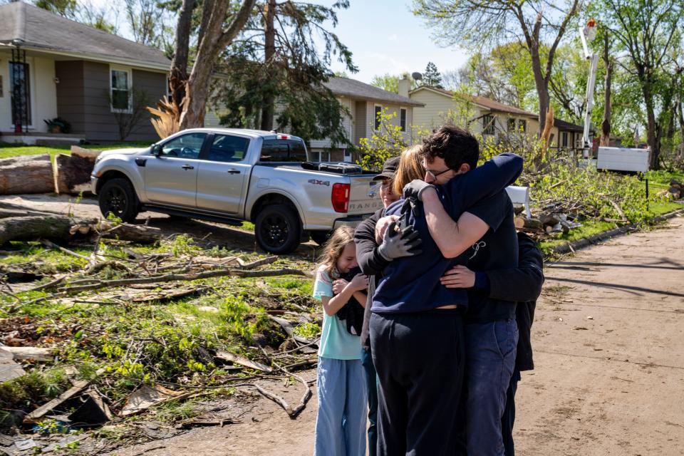 Neighbors embrace Penny Thomsen outside of her home in Pleasant Hill, Saturday, April 27, 2024. The Des Moines suburb was one of multiple cities hit as tornados ripped across the state Friday evening.