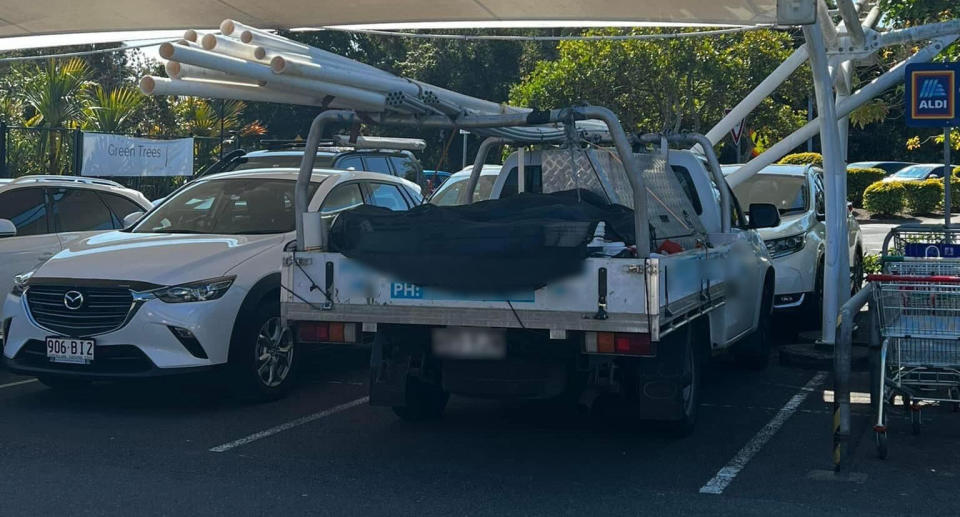 A driver parked their ute in an Aldi carpark with several poles hanging out at the back of the vehicle. Source: Facebook/ Belinda Bedggood