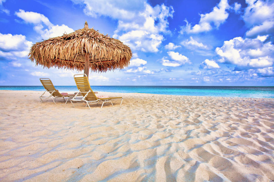 Two Lounge Chairs and Beach Umbrella on a White Sandy Beach in Aruba (Mark A Paulda / Getty Images)