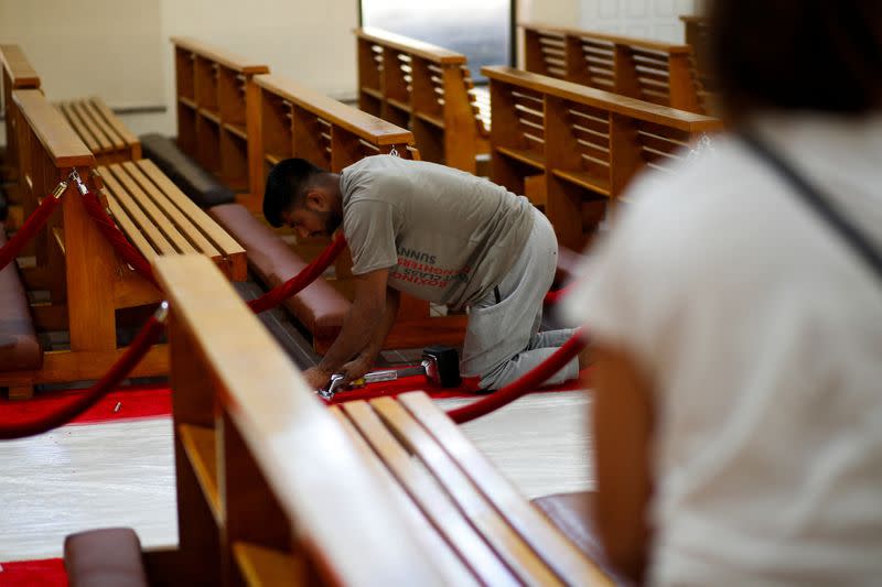 A worker takes on last minute set up ahead of Pope Francis arrival at Sacred Heart Catholic Church in Manama