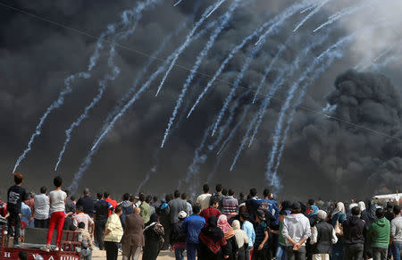 Tear gas canisters are fired by Israeli troops at Palestinian demonstrators during clashes at a protest demanding the right to return to their homeland, at the Israel-Gaza border, east of Gaza City, April 27, 2018. REUTERS/Mohammed Salem